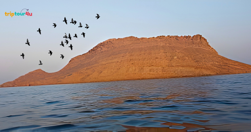 Churna Island near Karachi, featuring clear blue waters, rocky shoreline, and a popular spot for snorkeling, scuba diving, and boat trips.