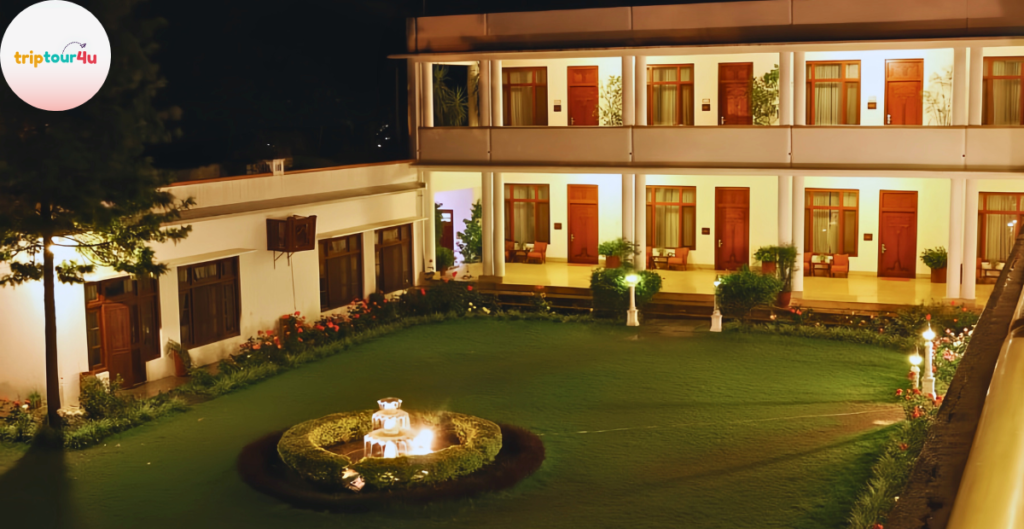 Night view of Serena Hotel Swat featuring a beautifully lit courtyard, green lawn, fountain centerpiece, and rooms with warm lighting on both floors.