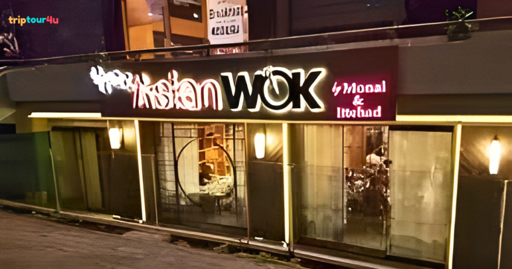 Exterior view of Asian Wok restaurant at night with illuminated signage and glass frontage.