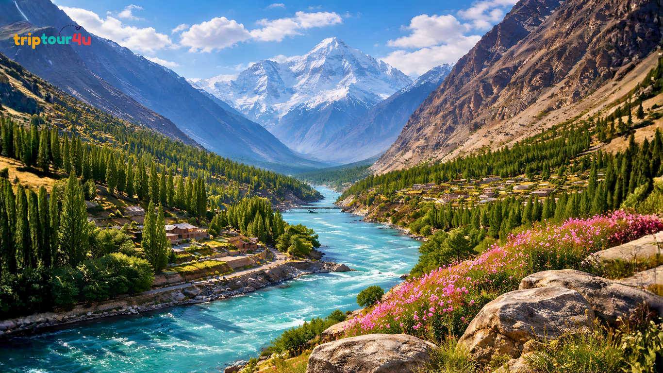 Turquoise river flowing through Gilgit-Baltistan valley with snow-capped mountains, green forests, terraced villages, and clear blue sky.