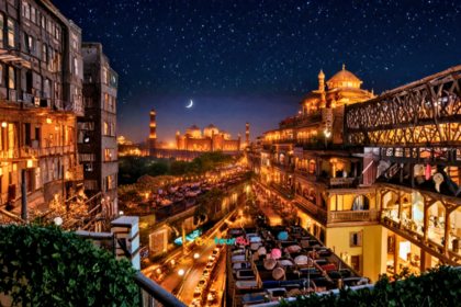 Illuminated Badshahi Mosque and Fort Road Food Street in Lahore at night with rooftop dining and crescent moon.