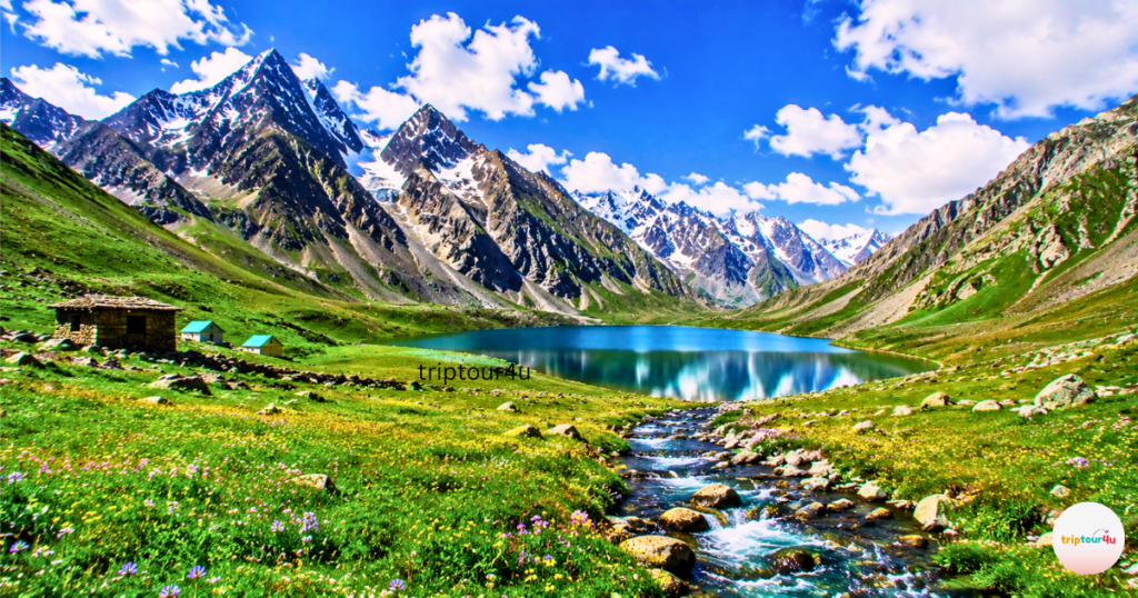 Broghil Valley in Upper Chitral (Pakistan) has sparkling alpine water, colorful meadows of wildflowers, snowcapped mountains, and a flowing mountain stream. Traditional stone huts are also visible under the bright summer skies.