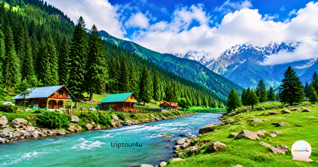 Kumrat Valley, Pakistan, with its turquoise river, green pastures, pine trees, wood cabins, and snow-capped mountains under a brilliant blue sky.