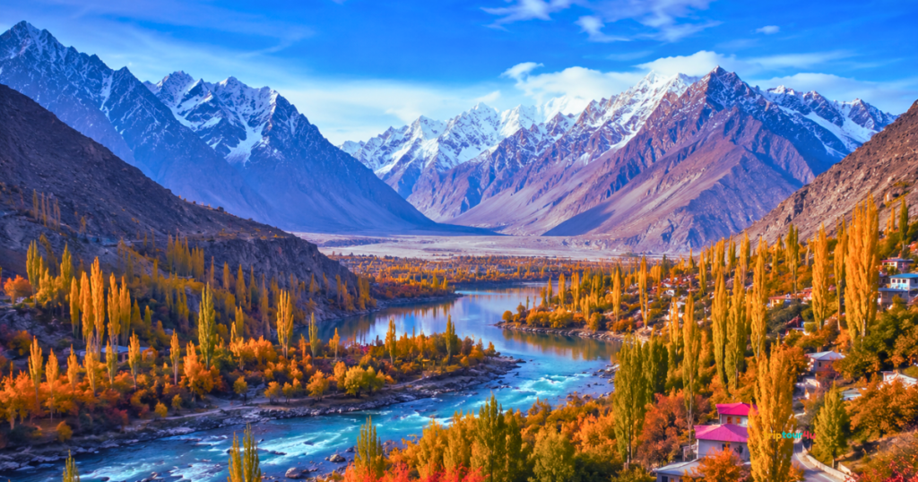 Skardu, Shigar Valley in the autumn, with its turquoise river, golden trees, and traditional mountain villages. The sky is clear and blue.