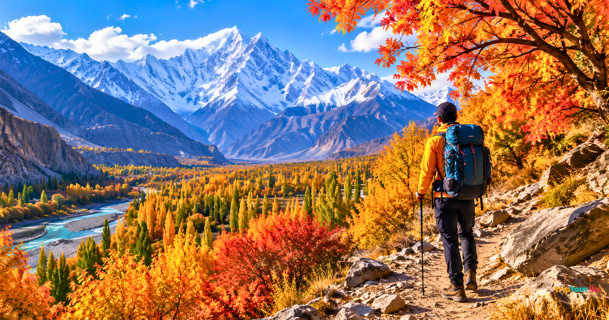 Hiker on an autumn trail overlooking golden valleys and snow-capped mountains in northern Pakistan